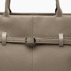 Close-up of the khaki genuine leather tote bag showcasing the elegant buckle design and fine stitching on the leather