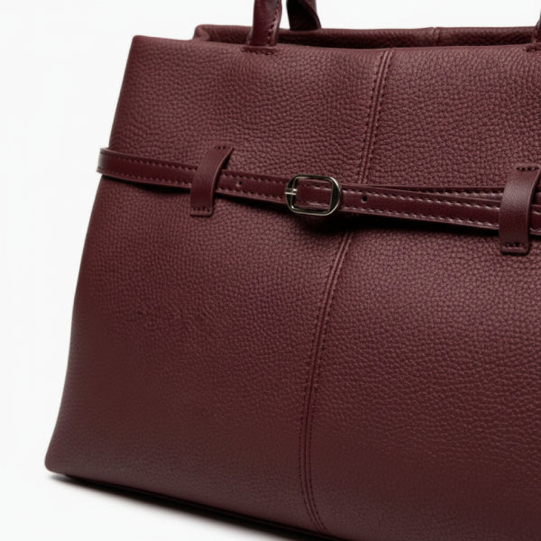 Close-up of the wine red genuine leather tote bag showcasing the refined buckle design and smooth texture of the leather