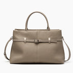 Front view of a khaki genuine leather tote bag featuring a simple yet sophisticated design with a central buckle accent
