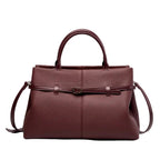 Front view of a wine red genuine leather tote bag with a sleek and sophisticated design, highlighted by the central buckle accent