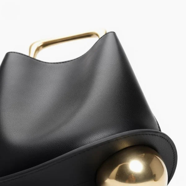 Close-up of a Black Izelia top grain leather crossbody bag with a gold handle on a white background