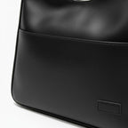Closeup of Seliora vegan leather shoulder bag in black color with front pocket and minimalist design