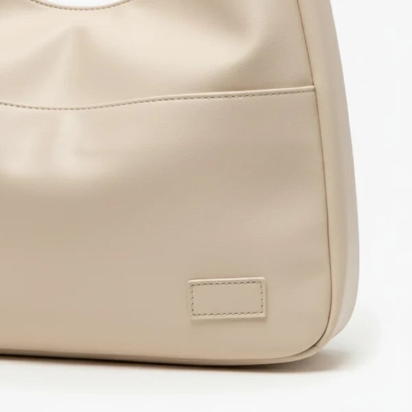 Closeup of Seliora vegan leather shoulder bag in off-white color with front pocket and minimalist design