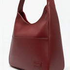 Closeup of Seliora vegan leather shoulder bag in wine red color with front pocket and sleek design