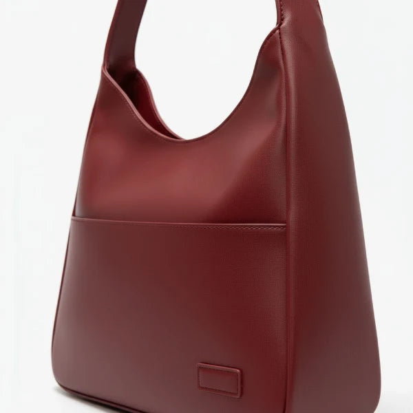 Closeup of Seliora vegan leather shoulder bag in wine red color with front pocket and sleek design