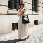 Model carrying Seliora vegan leather shoulder bag in black while walking outdoors in casual outfit