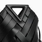 Seren Vegan Leather Bucket Bag in black, closeup highlighting geometric triangular handle and wide woven straps