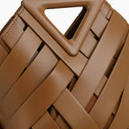 Seren Vegan Leather Bucket Bag in brown, closeup highlighting triangular top handle and wide woven straps