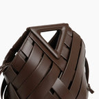 Seren Vegan Leather Bucket Bag in dark brown, closeup highlighting triangular top handle and wide woven straps