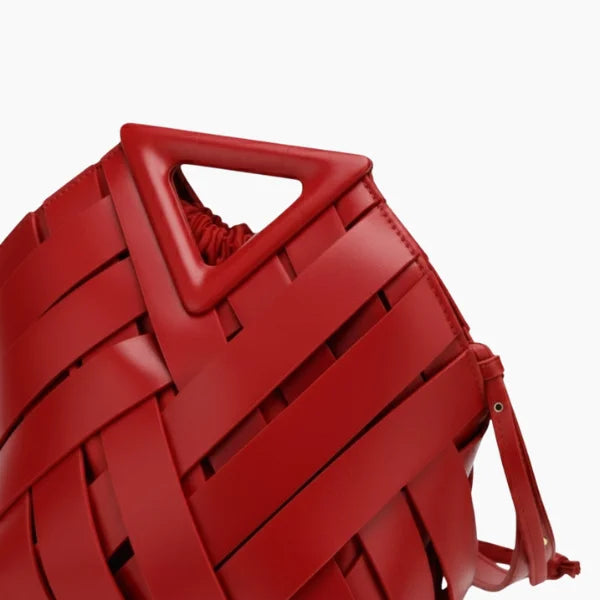 Seren Vegan Leather Bucket Bag in red, closeup highlighting triangular top handle and wide woven straps