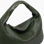Close-up of dark green woven vegan leather hobo bag with zipper closure and braided handle detail