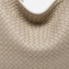 Close-up of off-white woven vegan leather hobo bag with zipper closure and smooth texture