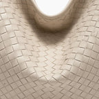 Close-up of white woven vegan leather hobo bag with detailed texture and smooth finish