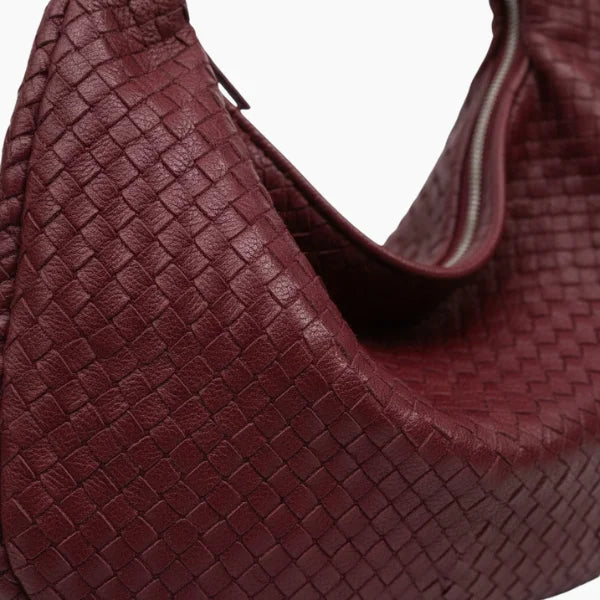 Close-up of wine red woven vegan leather hobo bag showcasing the intricate weave pattern and smooth texture
