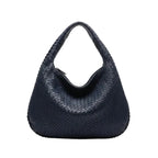 Front view of dark blue woven vegan leather hobo bag with a structured design, wide handle, and zipper opening