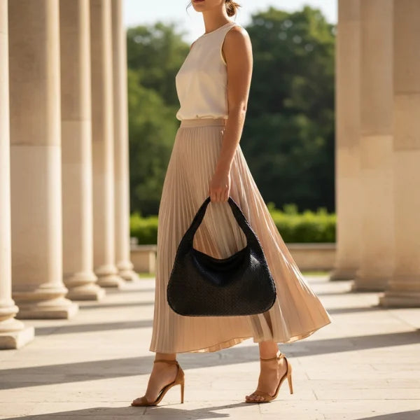 Valencia Vegan Leather Hobo Bag in black, lifestyle walking shot highlighting chic crescent silhouette for day to night
